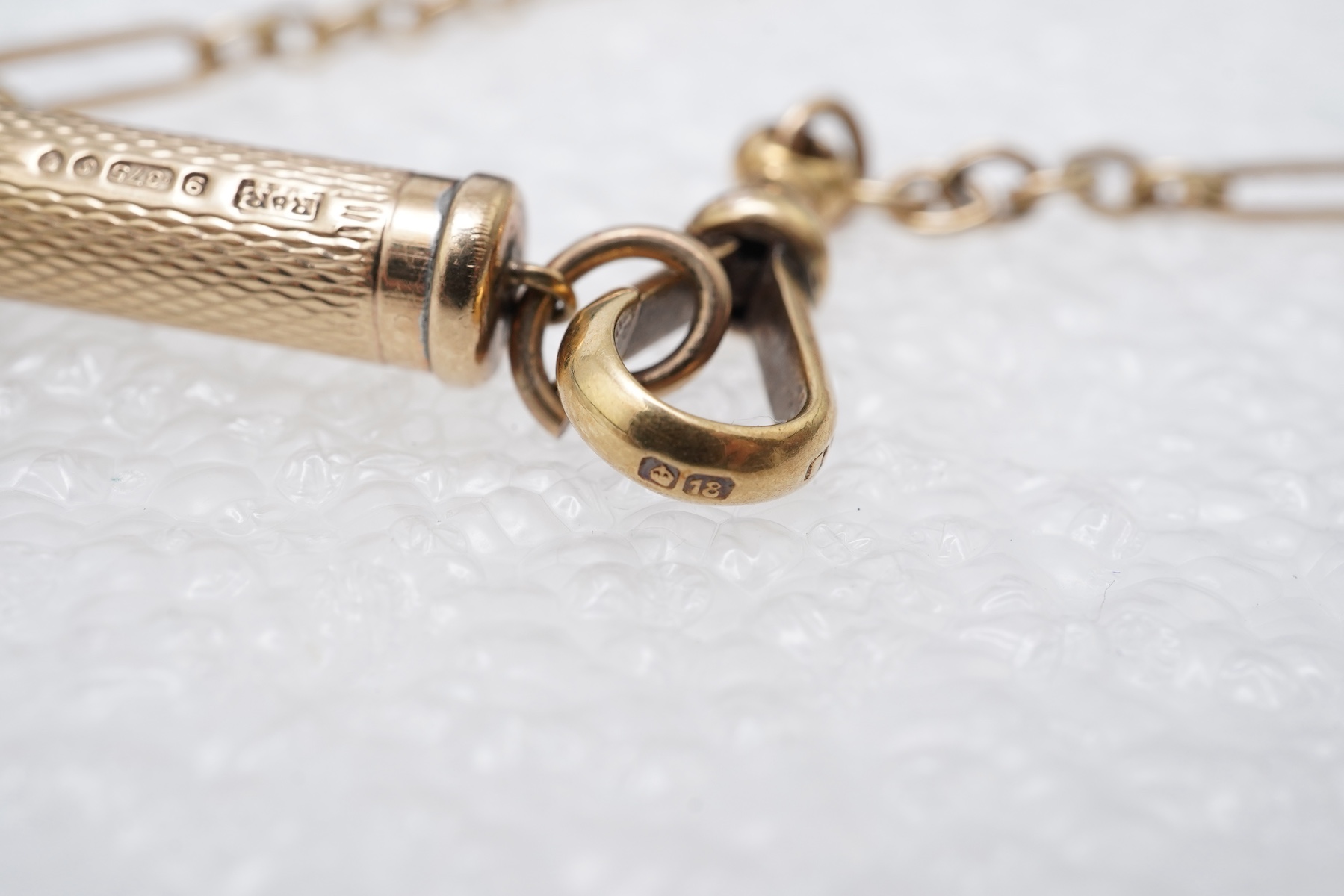 A gold watch chain, toothpick and fob seal